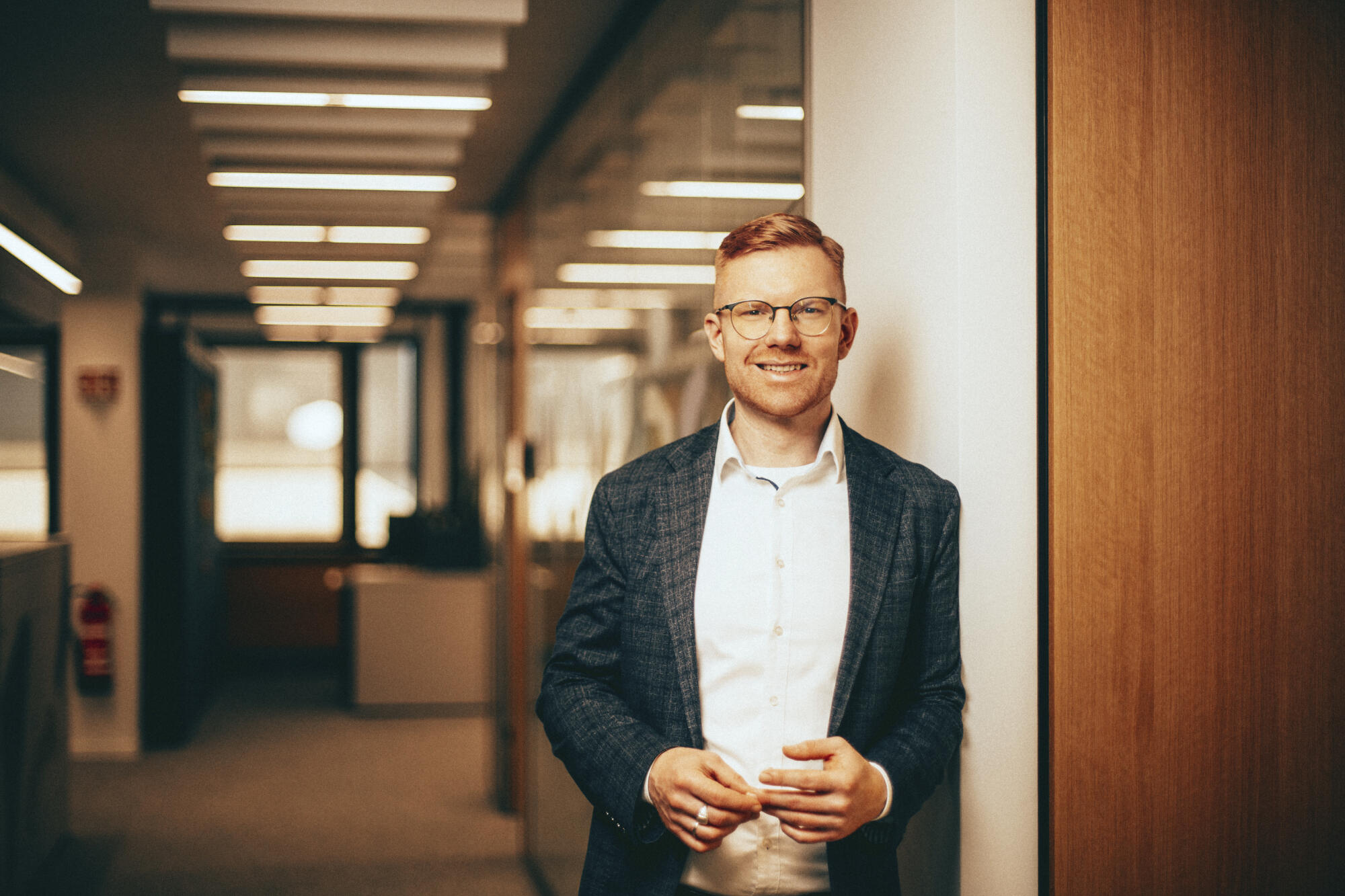 Portraitbild von Carsten Kothe auf einem Büroflur.