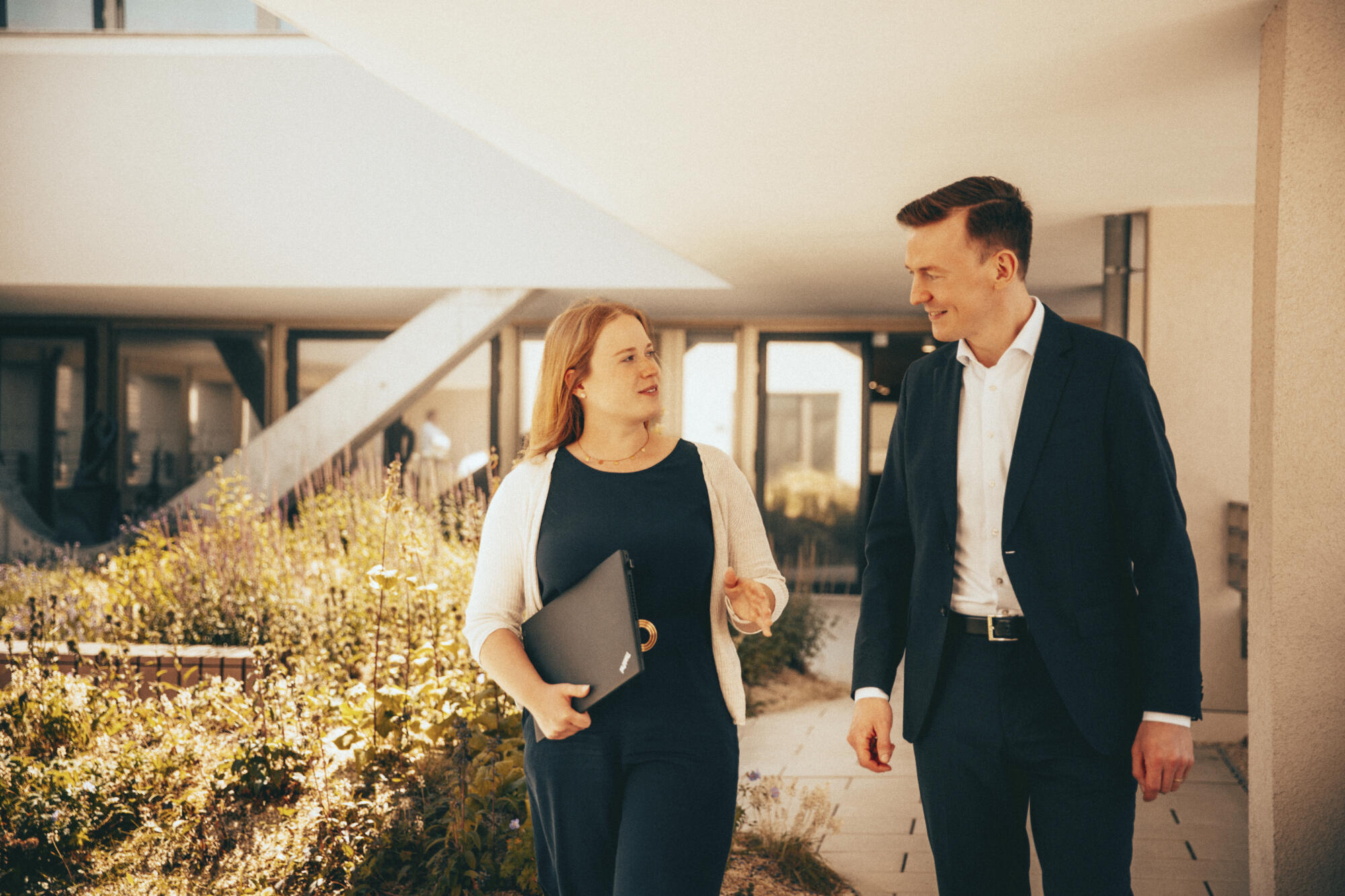 Lena Schöneweiß geht mit einem Kollegen über die Dachterrasse.