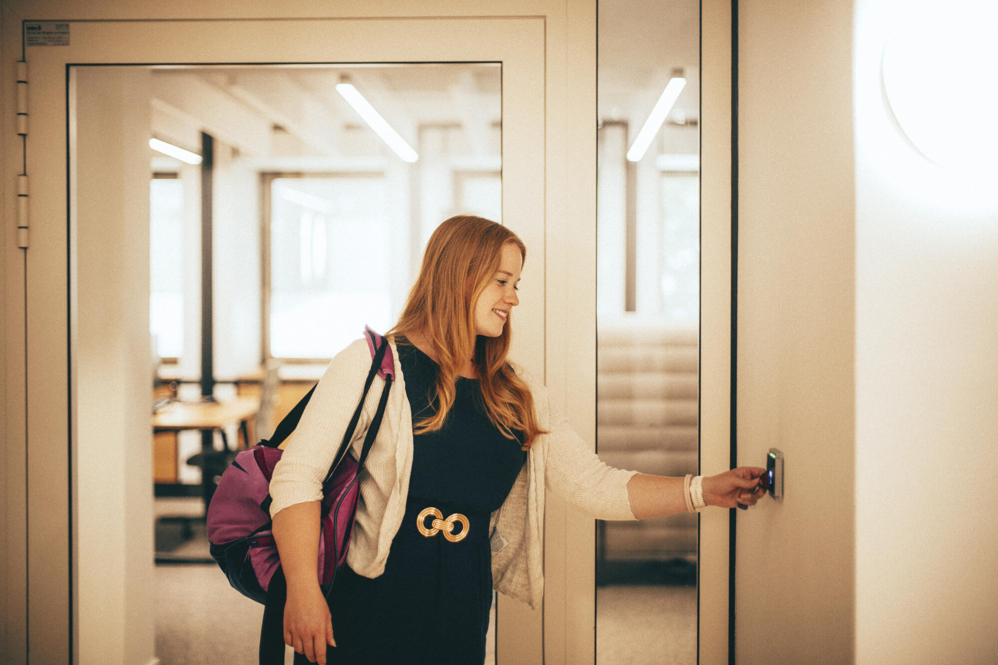 Lena Schöneweiß trägt eine Sporttasche über der Schulter und logt sich mit ihrem Chip am Terminal aus.